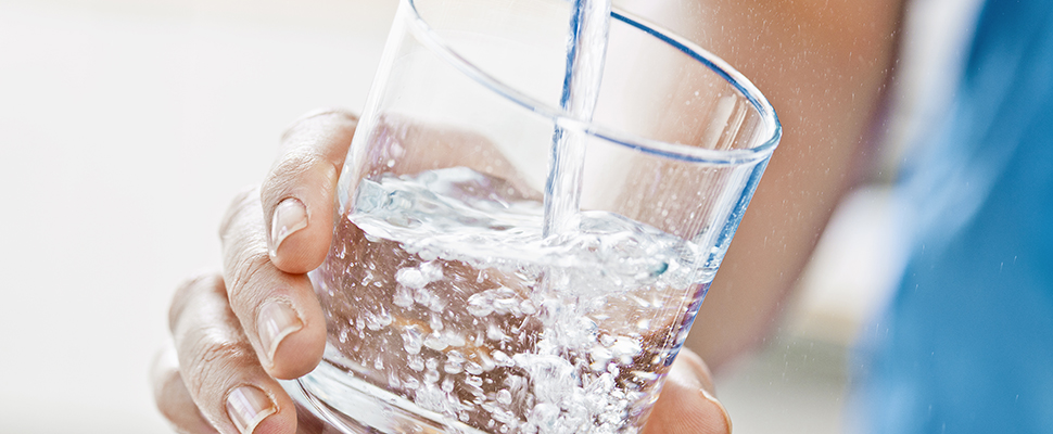 Spolar vatten i ett vattenglas.